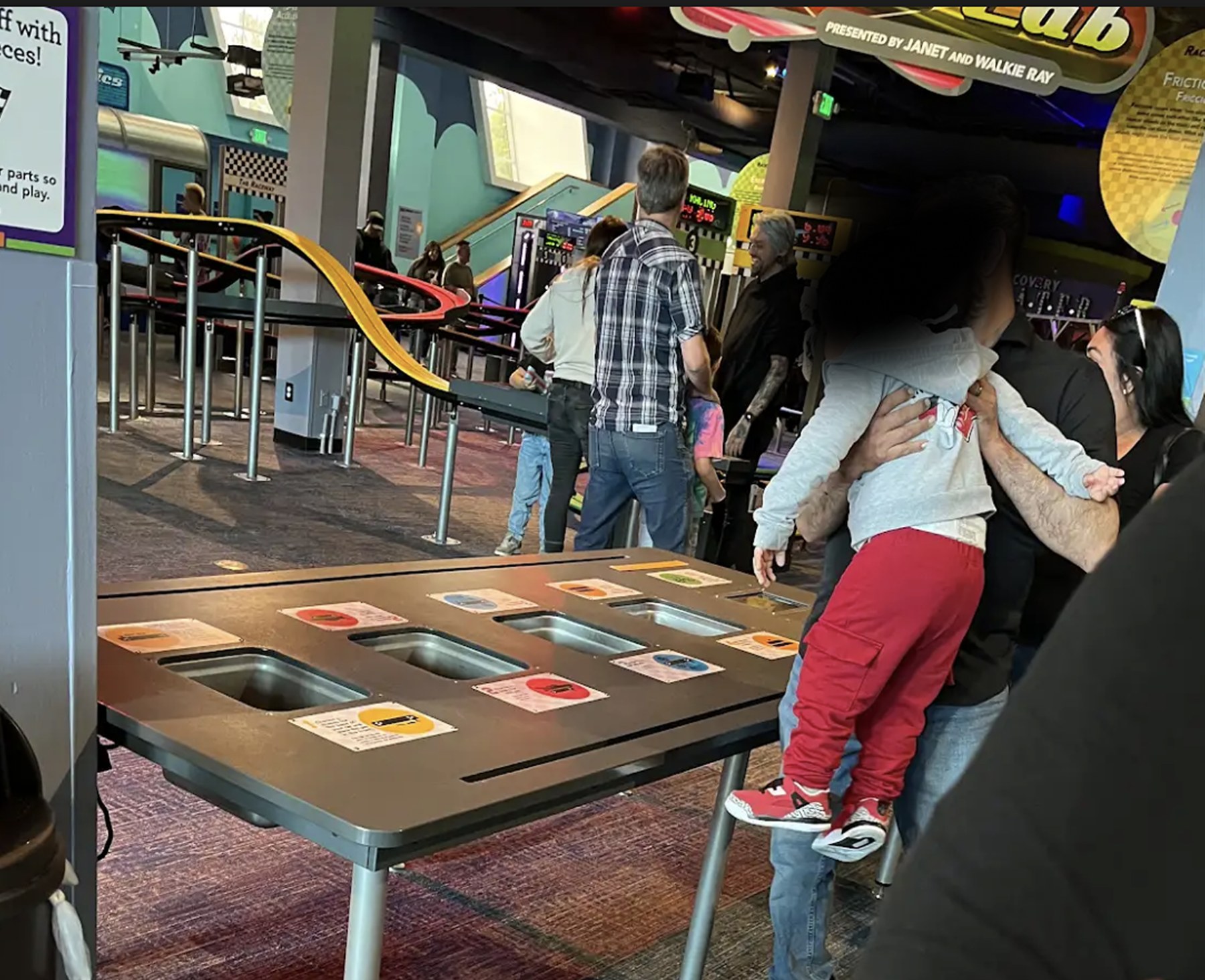 Museum visitors observing and interacting with a Discovery Cube exhibit during field research